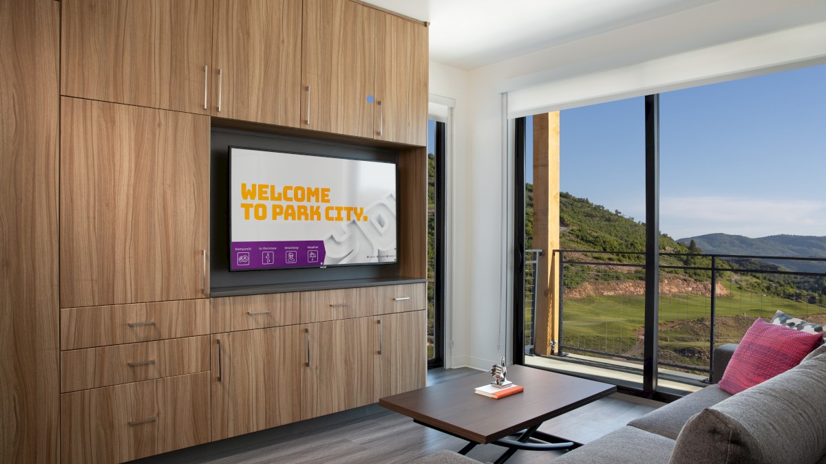 A modern living room features wood cabinetry, a TV with 